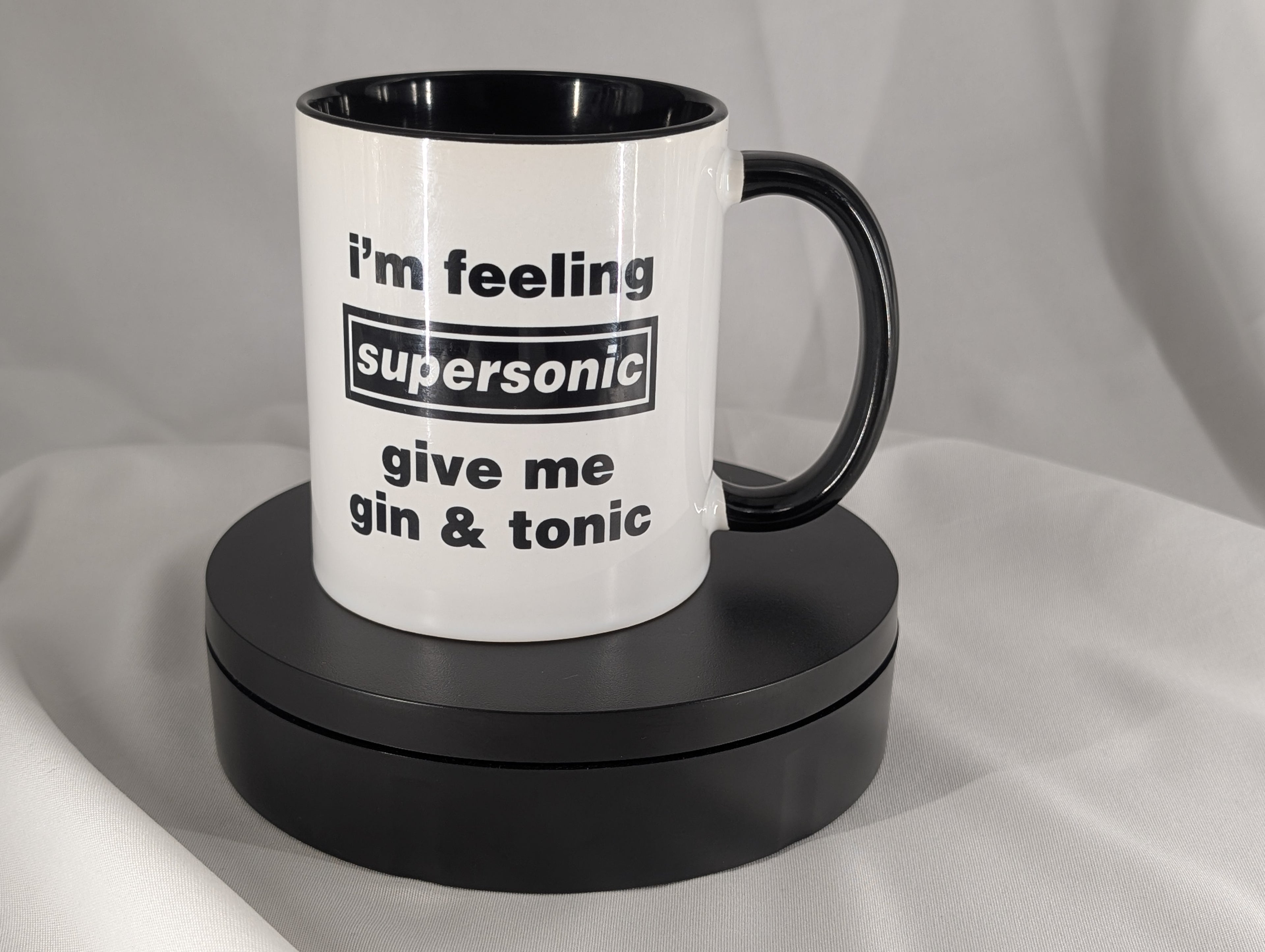White mug with black interior and handle, featuring text on a gray background