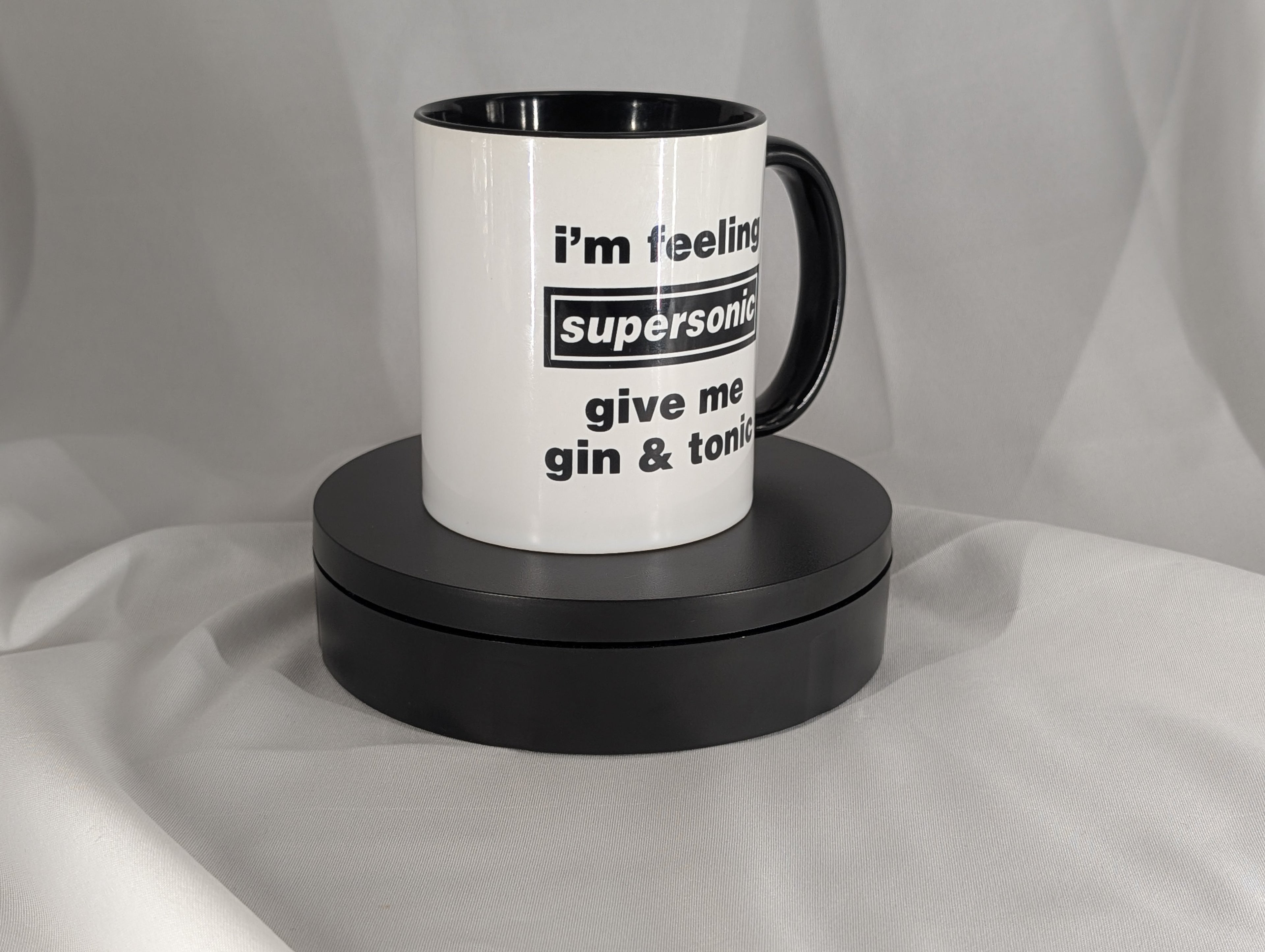 White mug with black interior and handle, featuring text on a gray background