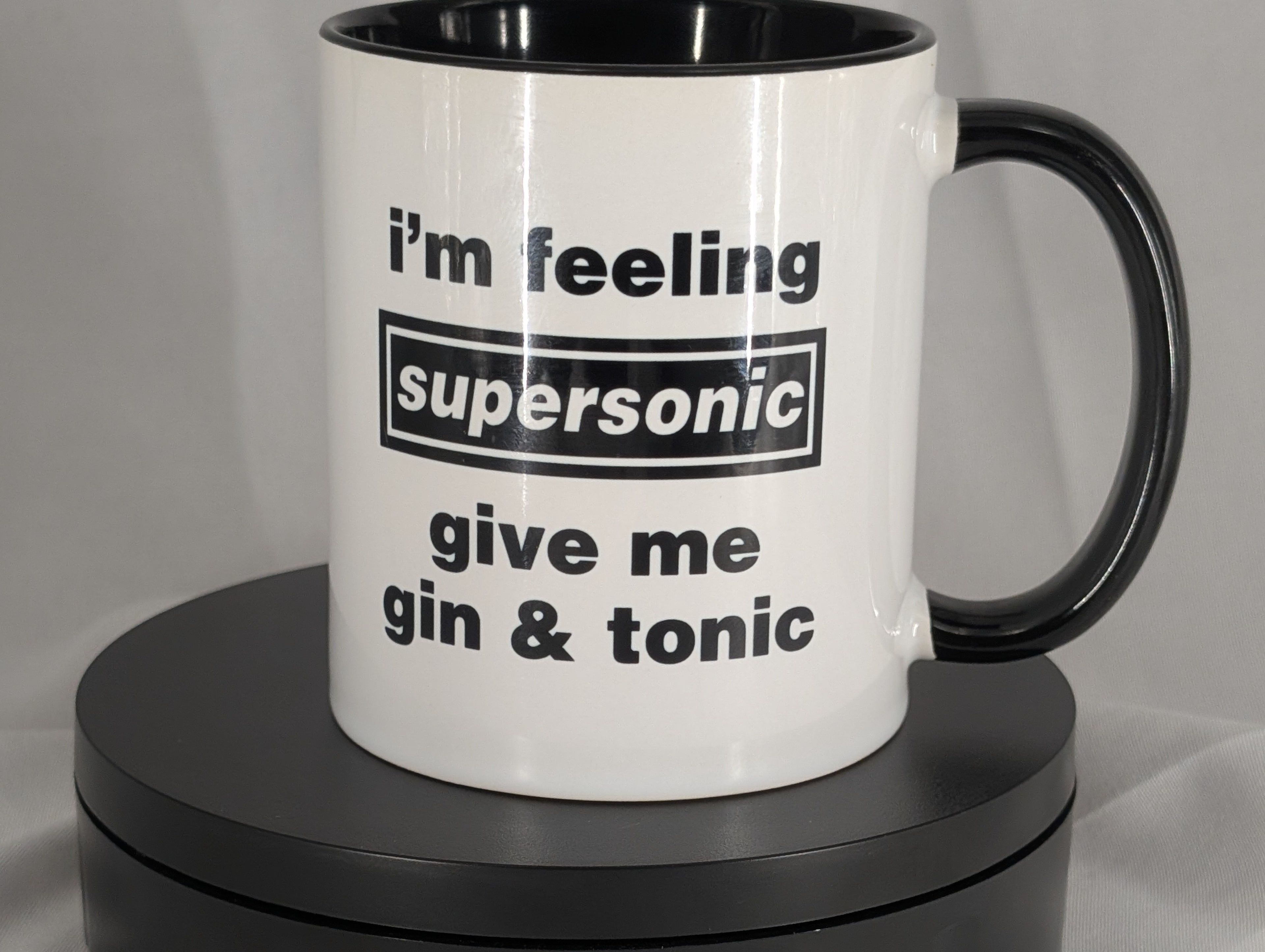 White mug with black interior and handle, featuring text on a gray background