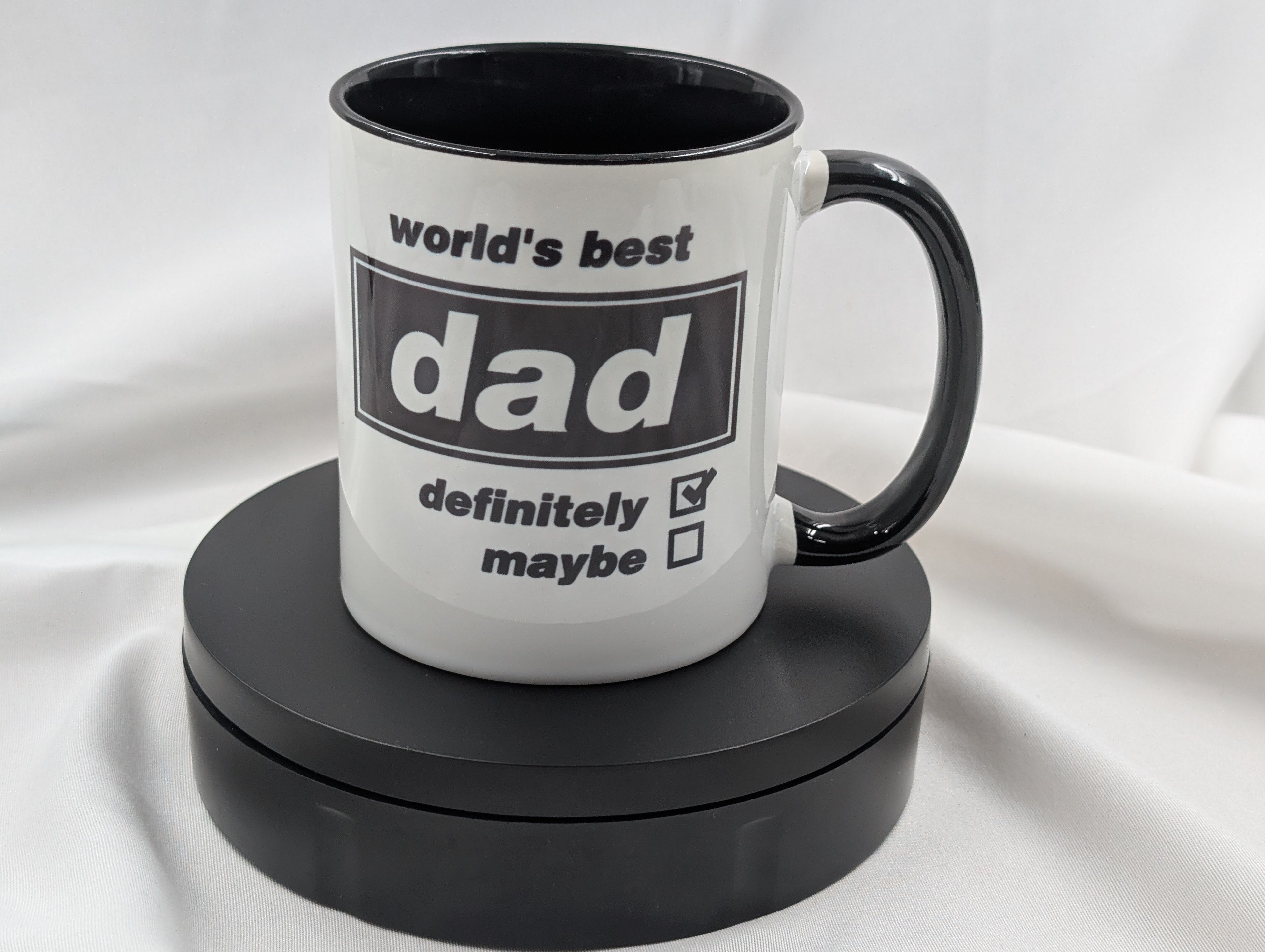 White mug with black interior and handle, featuring text on a white background